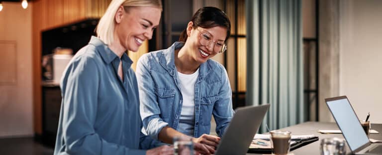 Smiling businesswomen working together on a laptop in an office