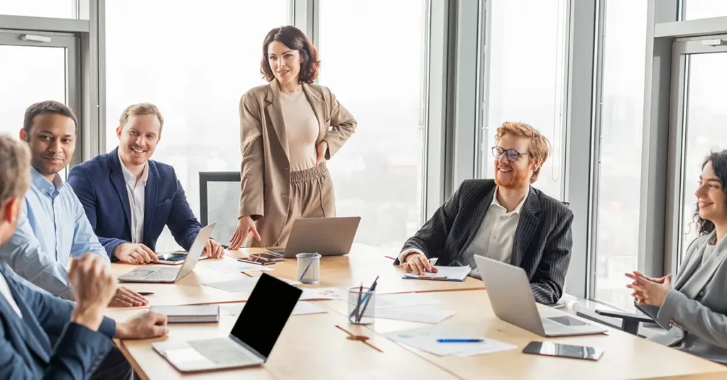 A group of business professionals are gathered around a large conference table reviewing legal GenAI assistants